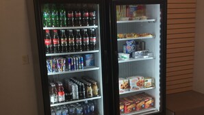 Twee automaten gevuld met diverse drankjes en snacks.