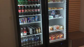 Two beverage vending machines stocked with various drinks and snacks.
