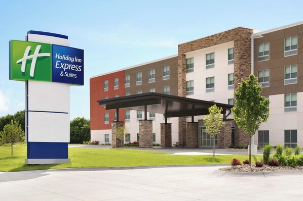 A Holiday Inn Express & Suites building with a modern design, featuring a covered entrance and a landscaped area with trees and shrubs. - Holiday Inn Express and Suites Nebraska City by IHG (Nebraska City)