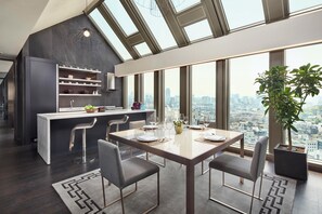 Eine moderne Küche mit Blick auf die Stadt, ein Essbereich mit Tisch für vier Personen und ein großes Fenster.