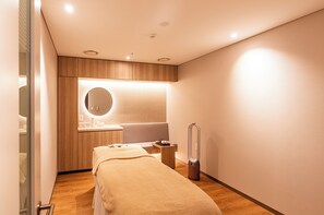 Ein modernes Schlafzimmer mit Bett, Nachttisch, Spiegel und integriertem Schminktisch mit rundem Spiegel.