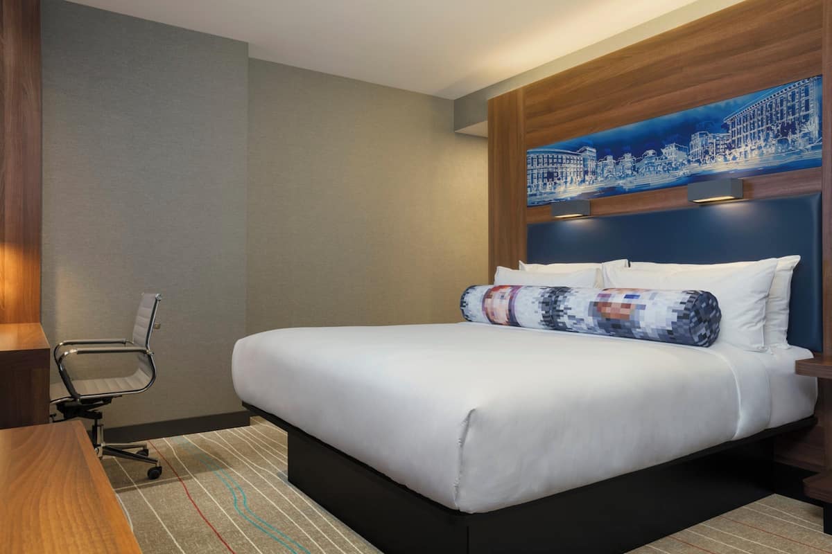 Una habitación de hotel con una cama grande, un escritorio y una silla.
