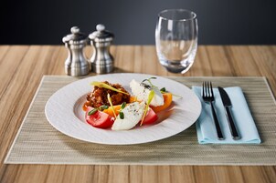 Un plato de comida con un tenedor y un cuchillo sobre un mantel individual.