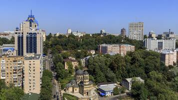 A cityscape with a mix of modern and historic buildings, including a prominent tower and a church with domes.