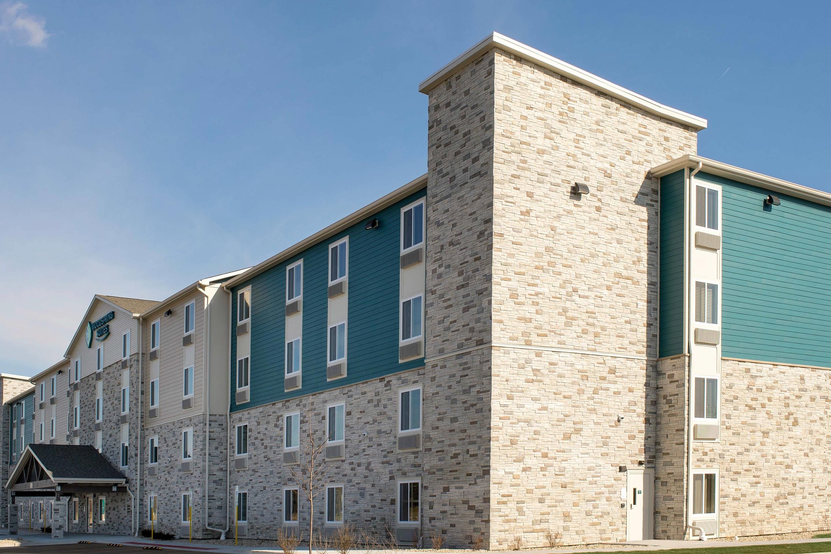 A multi-story hotel with a stone facade and teal-colored upper sections.