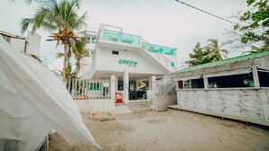 Um edifício com uma placa que diz "GREEN" e uma área externa coberta com uma escadaria que leva a um andar superior.
