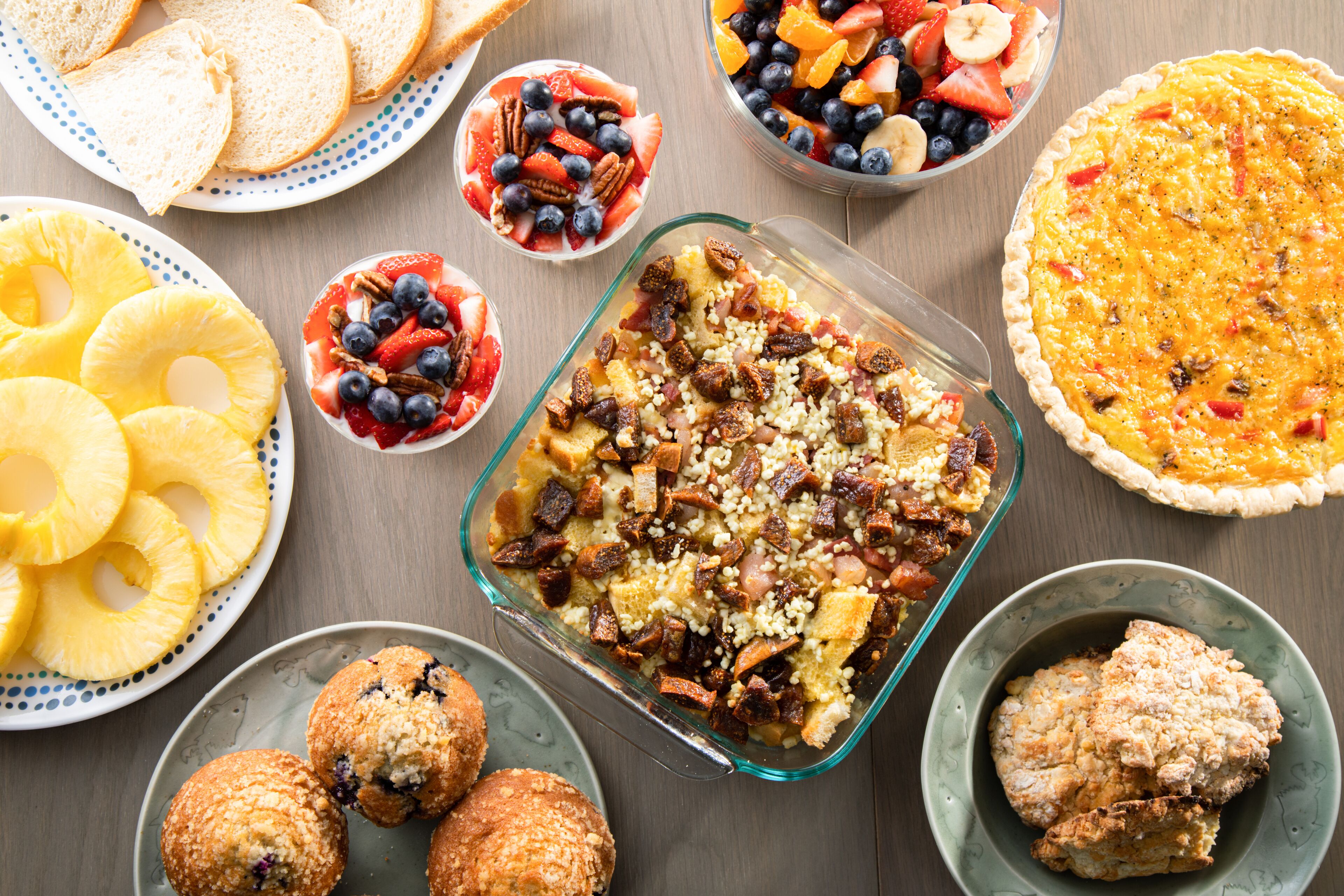 Variedad de opciones para el desayuno, como quiche, ensaladas de frutas, muffins y tostadas.