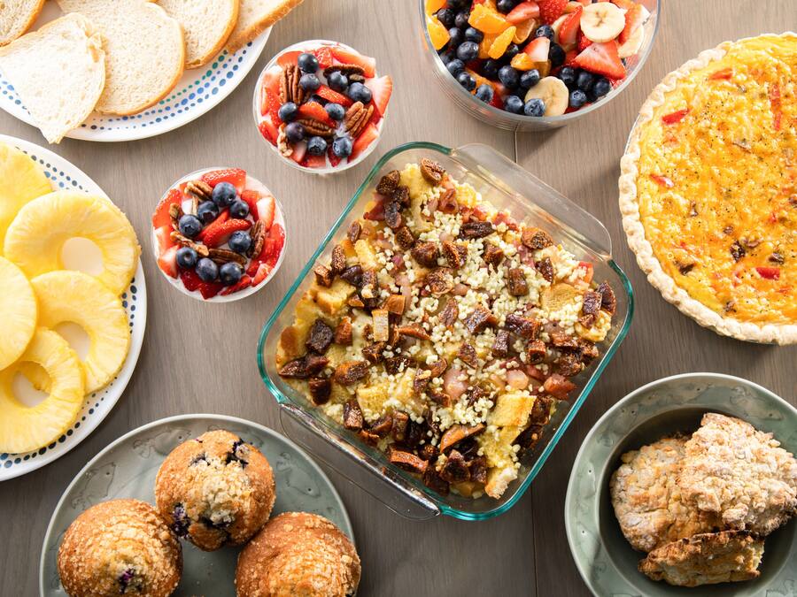 Variedad de opciones para el desayuno, como quiche, ensaladas de frutas, muffins y tostadas.