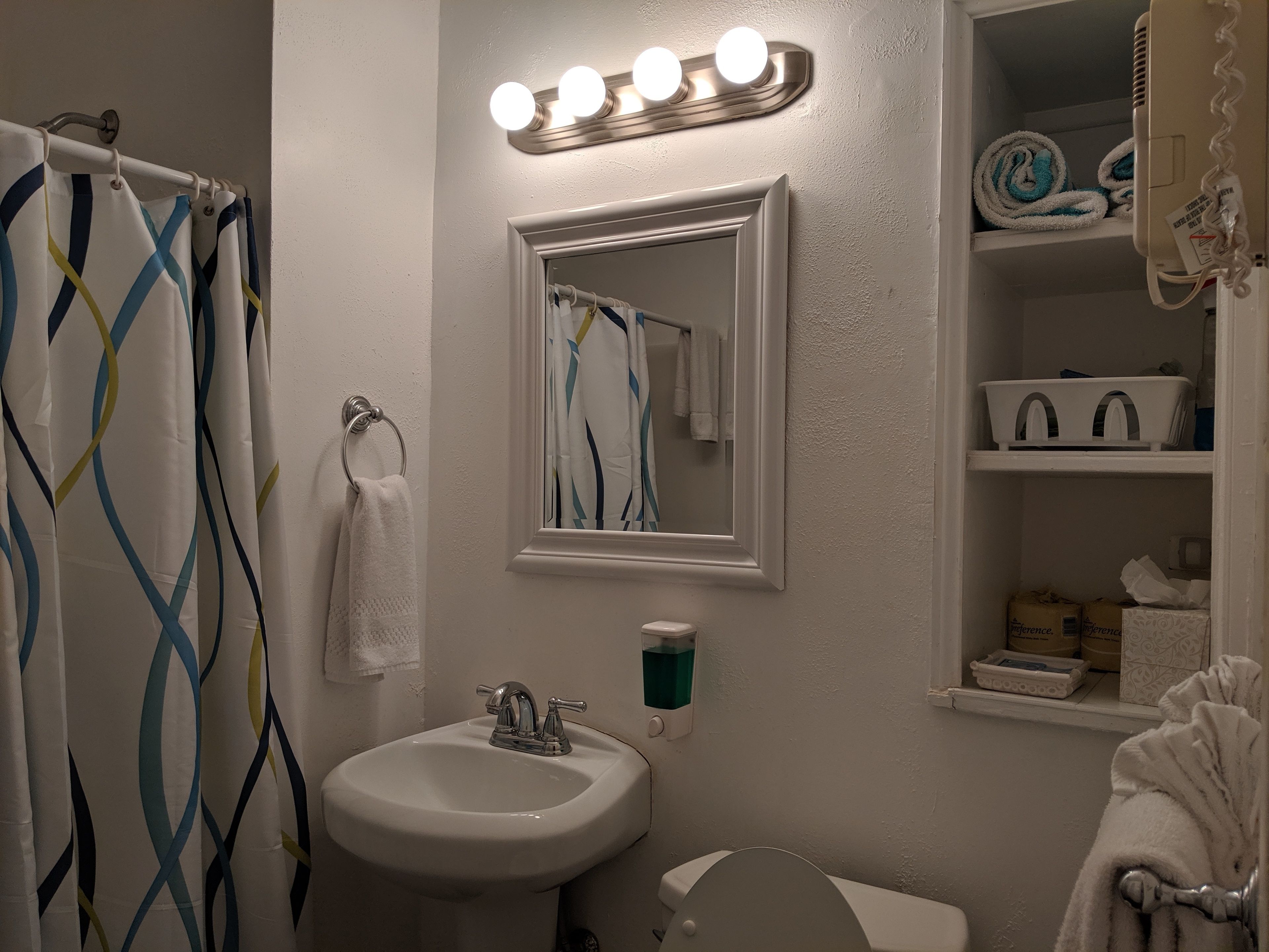 A bathroom with a sink, mirror, and vanity.