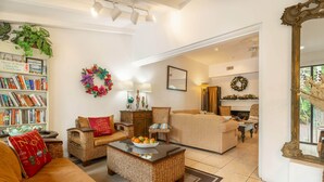Una sala de estar acogedora con chimenea, una estantería y un rincón de estar cómodo.