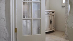 A white door with a window, a white cabinet with black handles, and a tiled floor. - Ash Mill Farm Bed & Breakfast (Holicong)