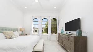 A bedroom with a bed, bench, dresser, TV, and windows. - NEW FURNITURE Aug 2026 | Movie Theater & Games Room | Golf Course Views (Kissimmee)