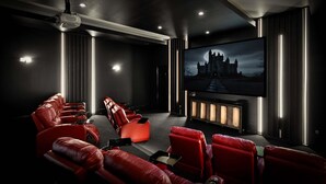 A home theater room with red leather seating, a large flat-screen TV, and a fireplace. - NEW FURNITURE Aug 2026 | Movie Theater & Games Room | Golf Course Views (Kissimmee)