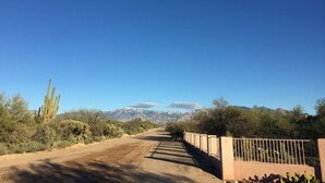 A dirt road with a metal fence on one side and cacti on the other. - NW Tucson - Roomy 20 Foot RV Nestled On A 3 Acre Property Sleeps 4 (Tucson)