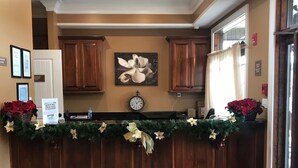 A kitchen with wooden cabinets, a clock, and a Christmas garland. - Magnolia Creek Lodge (Cottonwood)