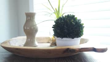 Una bandeja de madera con una pequeña planta en maceta y un jarrón sobre una mesa.