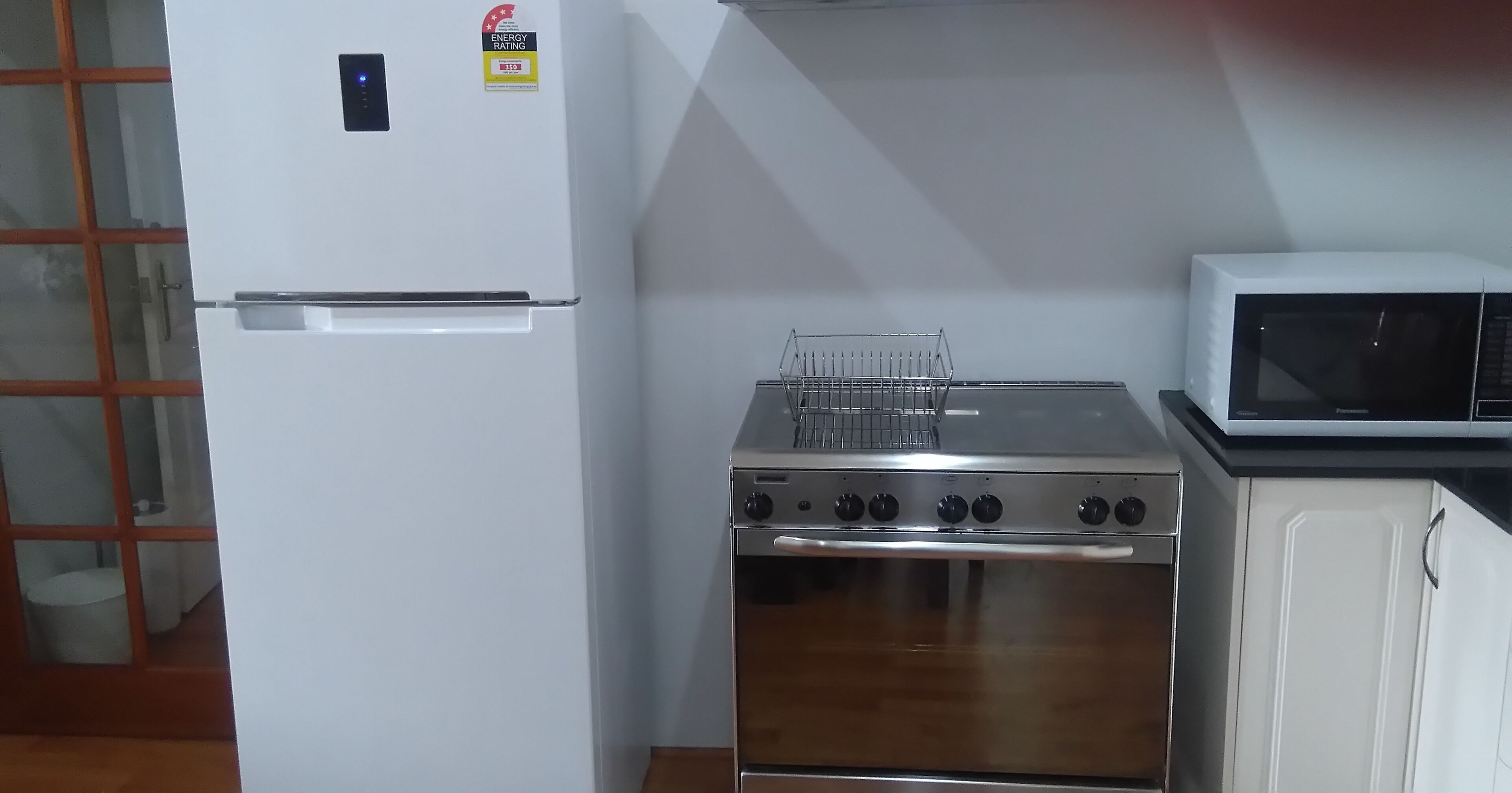 Une cuisine avec un réfrigérateur blanc, une cuisinière et un four à micro-ondes.
