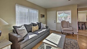 A living room with a gray sofa, a coffee table, and a ceiling fan. - East Tucson Home w/ Backyard, Patio & Fire Pit (Tucson)