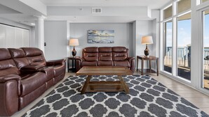 A modern living room with a brown leather sofa, a wooden coffee table, and a patterned rug. - Myrtle Beach Vacation | Pool & Ocean Views | Summer Sun | OB 502 (Myrtle Beach)