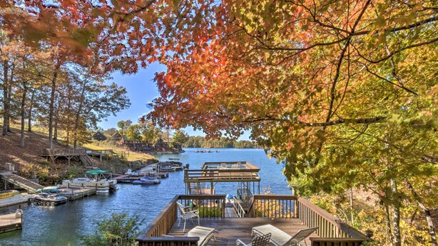A dock with boats, a wooden deck with chairs, and a view of a lake surrounded by trees. - Lake Keowee Escape w/ Dock, Deck & Lake Access! (Six Mile)
