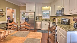 A modern kitchen with white cabinets, stainless steel appliances, and a granite countertop. - Lake Keowee Escape w/ Dock, Deck & Lake Access! (Six Mile)
