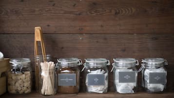 Five glass jars with labels on a wooden surface.