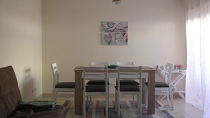 Un área de comedor con una mesa, sillas y un sofá.