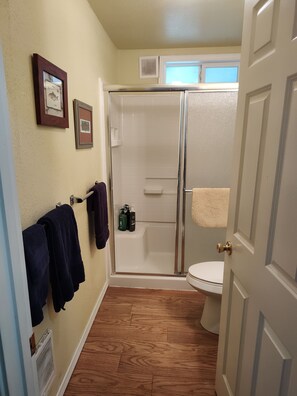 A bathroom with a shower, toilet, and towel rack. - Beautiful two bedroom one bath house overlooking the Siuslaw river. (Mapleton)