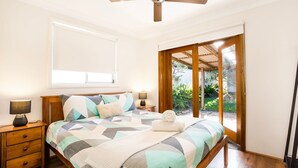 Una camera da letto con un letto, comodini, una finestra e vista sull'esterno.