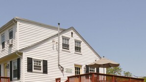A two-story white house with a porch and a covered area.