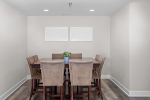 A dining room with a wooden table and six chairs, a vase with a plant, and two wall-mounted decorative panels. - Towers 9106 - Four Bedroom Apartment, Sleeps 10 (Osage Beach)