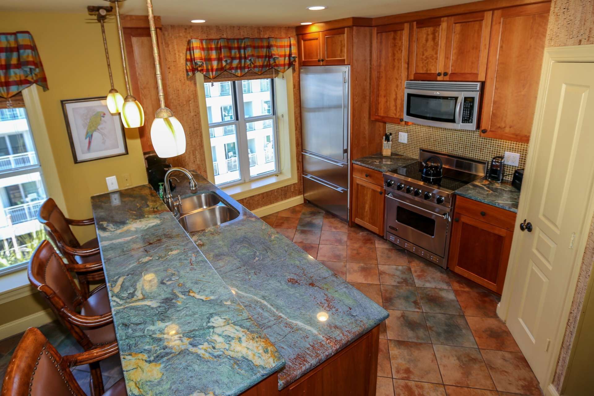 A kitchen with a large island, stainless steel appliances, and wooden cabinets.