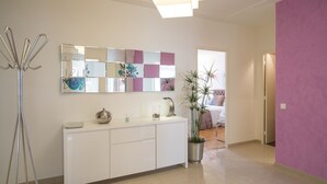 A modern bathroom with a white vanity, a mirror, and a potted plant. - Violet 2 bedroom apartment (Nice)