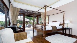Un lit à baldaquin dans une pièce bien éclairée, avec vue sur une piscine et un espace salon extérieur.