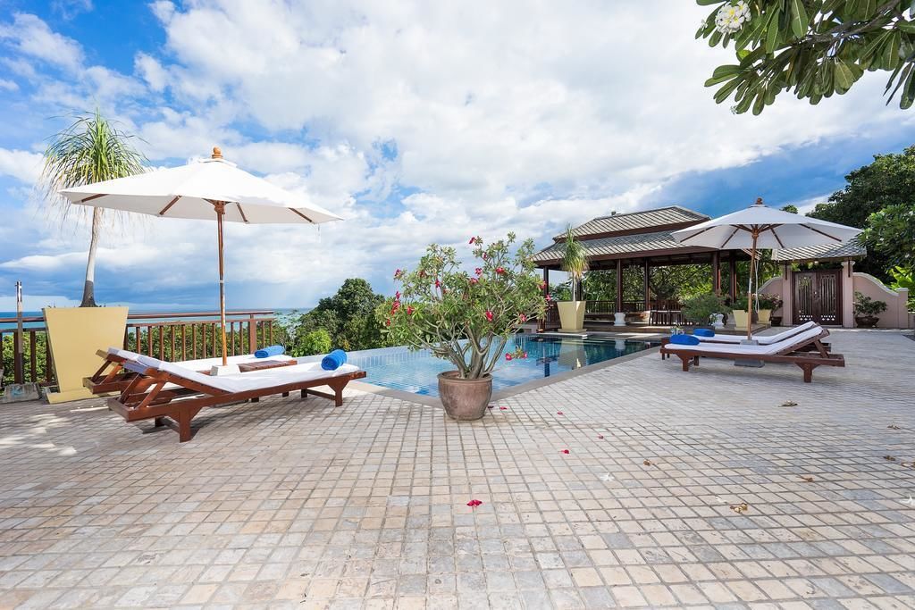 A poolside area with lounge chairs and umbrellas, a small garden, and a gazebo.