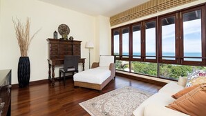 Une chambre avec une grande fenêtre, un lit, un bureau et une commode.