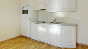 A kitchen with white cabinets, a built-in oven, and a stainless steel sink. - Yasmin 1 bedroom apartment (Nice)