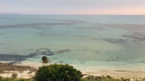 A coastal landscape with clear waters, a sandy beach, and a rocky outcrop. - Carabollace Estate - Mistral (Sciacca)