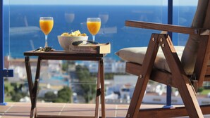 A dining table with a bowl of cereal and two glasses of orange juice, a wooden chair, and a view of the ocean. - TOPLIGGING: Luxury penthouse, golf, terrace 180 ° fantastic sea view, free Wifi (Mojácar)
