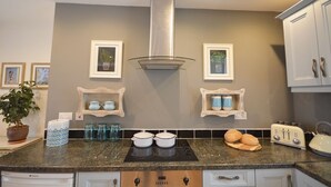 A kitchen with granite countertops, a stainless steel range hood, and a toaster. - Morning Side 4 bedroom house VRBO (Dingle Peninsula)