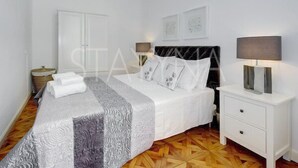 A neatly arranged bedroom with a bed, bedside tables, and a wardrobe. - Minuet - 1 bedroom apartment (Nice)