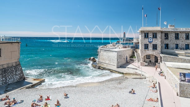 A coastal building with a stone facade, a flagpole, and a sign indicating it is a nautical club. - Coco 2 bedroom apartment VRBO (Nice)