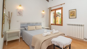 A bedroom with a bed, bedside tables, a window, and a radiator. - CASA MIRANDA - Chalet with terrace in Valldemosa. Free WiFi (Valldemossa)