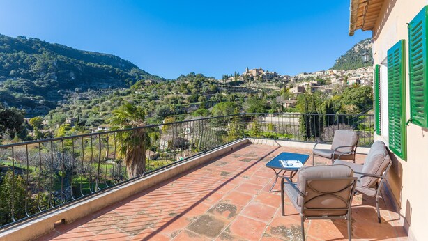 A terrace with a table and chairs, overlooking a hillside village. - CASA MIRANDA - Chalet with terrace in Valldemosa. Free WiFi (Valldemossa)