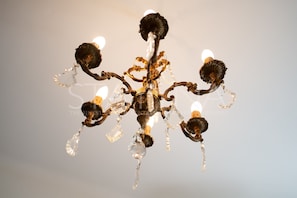 Un lustre à plusieurs bras, orné de décorations en cristal.