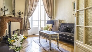 A living room with a fireplace, a sofa, a coffee table, and a large mirror.