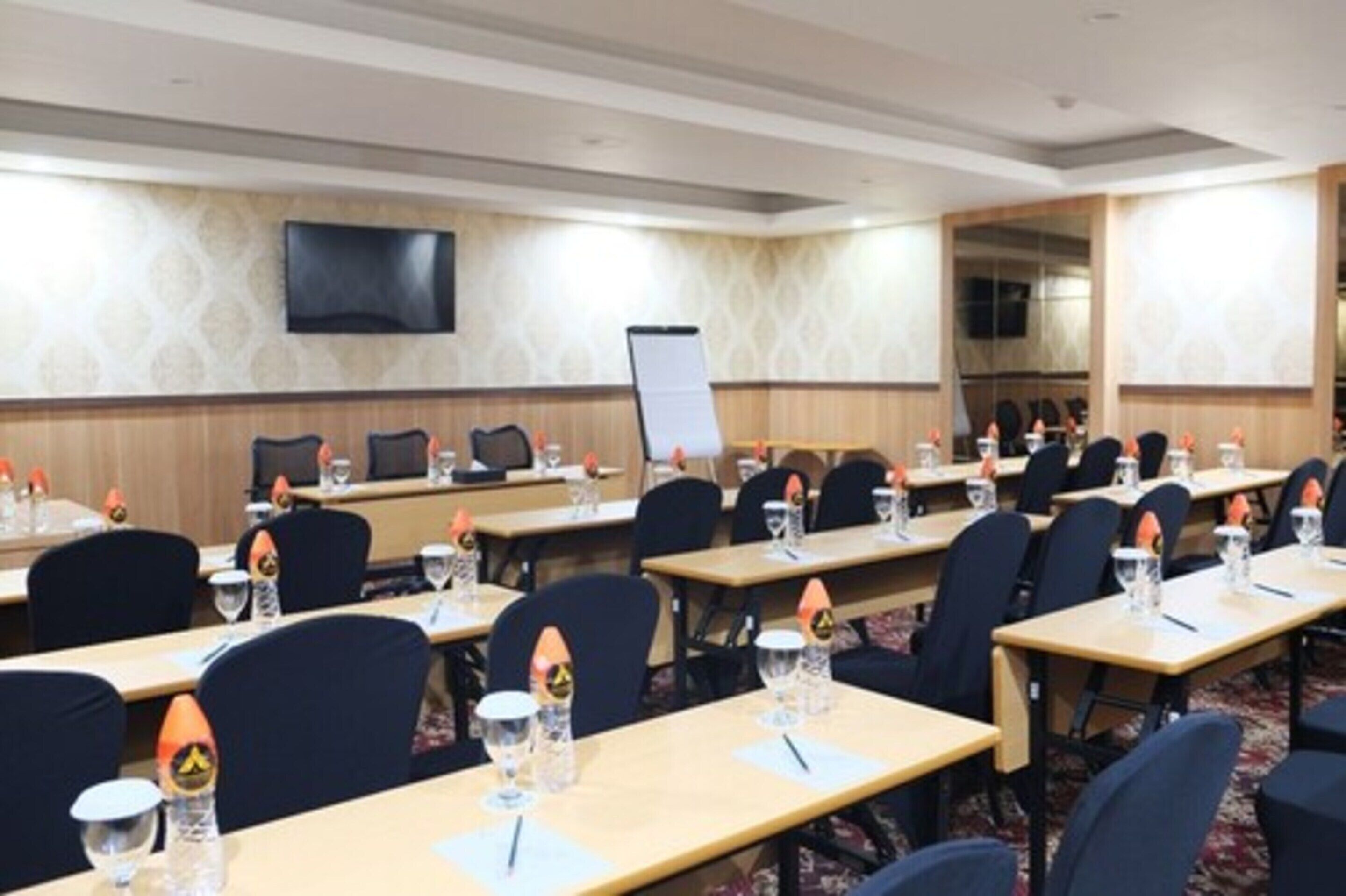 A conference room with multiple tables, chairs, and a whiteboard.