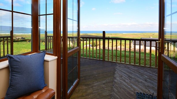 Un balcon avec vue sur la mer et les champs.