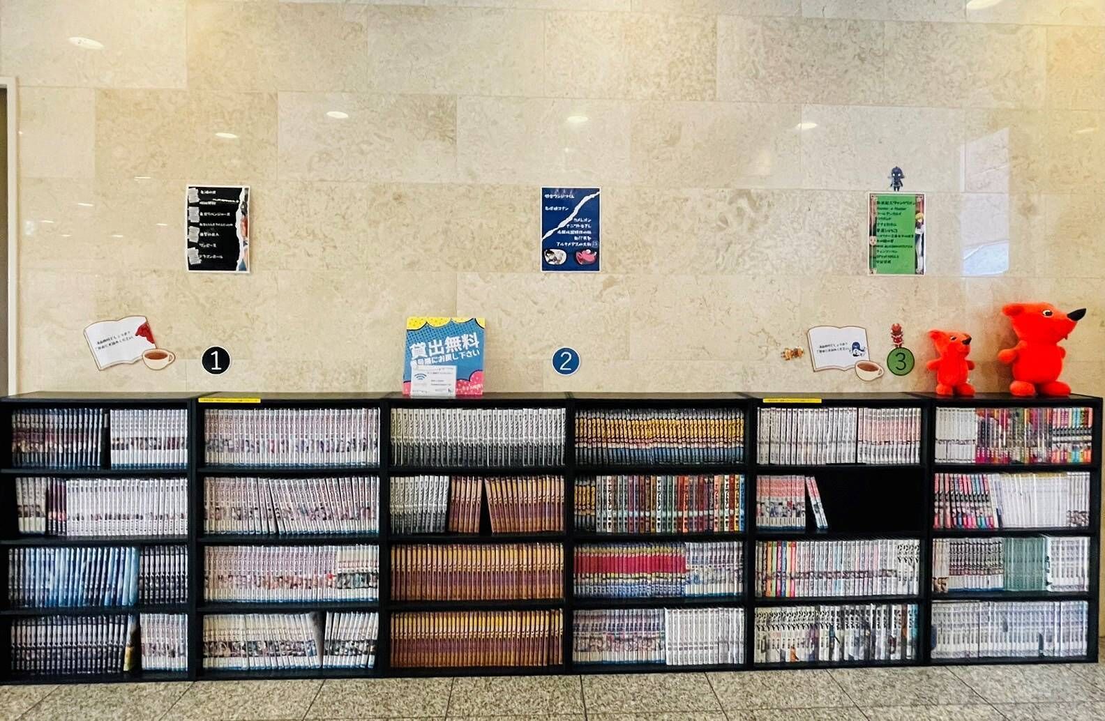 Una biblioteca con estanterías llenas de libros y carteles informativos en la pared.