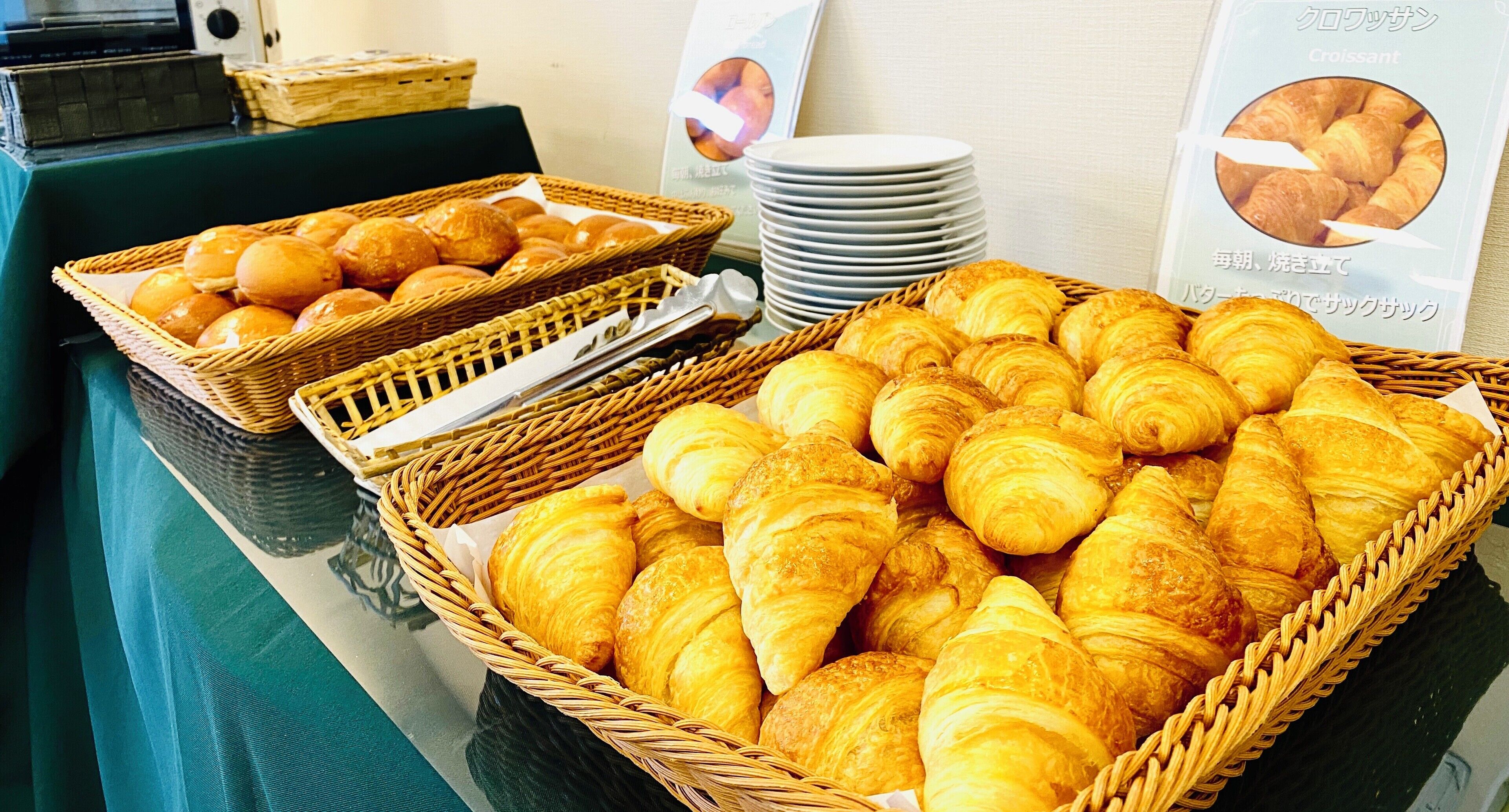Ett buffébord med korgar fulla av croissanter och frallor.
